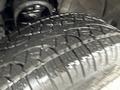 Close-up of a wet tire tread from a 2015 GMC Sierra 1500 showcasing deep grooves and uneven wear