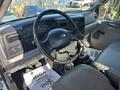 Interior view of a 2004 Ford F-750 featuring a steering wheel dashboard gear shifter and seating area with fabric mats on the floor