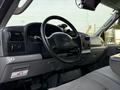 The interior of a 2006 Ford F-550 featuring a steering wheel dashboard and control panels