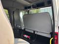 Interior view of a 1999 Freightliner FL80 showing the back of two driver seats a fire extinguisher and a gray wall panel