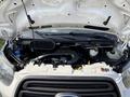 Engine compartment of a 2016 Ford Transit 150 with various components visible including hoses and fluid reservoirs