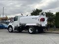 A 2025 Peterbilt 536 water truck with a large white tank mounted on the back and red detailing on the side
