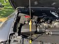A 2021 Jeep Gladiator engine with a yellow dipstick visible next to the open engine compartment showcasing various components and the Jeep logo
