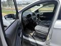 Interior of a 2015 Ford Escape showing the driver's seat steering wheel and dashboard with controls and fabric upholstery