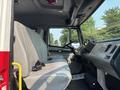 Interior view of a 1999 Freightliner FL80 showing two gray seats with seatbelts and a dashboard with controls and instruments