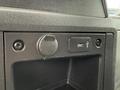 Close-up of a dashboard compartment featuring a round power outlet and a USB port with a textured black surface