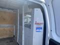 Interior view of a 2022 GMC Savana cargo van showing a partition wall and wood paneling on the sides