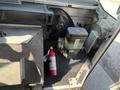 A 2012 Ford Econoline van interior featuring a fire extinguisher on the floor and various mechanical components visible near the driver’s side