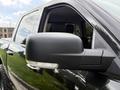 A close-up view of the side mirror of a 2018 RAM 1500 showing a sleek black design with an integrated light