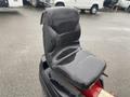 A black seat from a 2017 Ferris Rotary mower with a curved backrest and a smooth surface showing signs of wear and water exposure