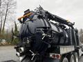 A 2018 Kenworth T800 truck featuring a large black vacuum tank with numerous hoses and valves attached to its rear