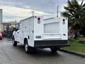 A 2017 Ford F-350 SD truck with a utility bed and a white exterior positioned on a paved surface