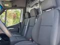 Interior of a 2019 Mercedes-Benz Sprinter featuring two front seats in black upholstery with seatbelts and a simple dashboard design