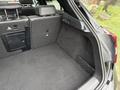 The image shows the spacious cargo area of a 2016 Mercedes-Benz GLA-250 featuring a dark carpeted floor and side storage compartments