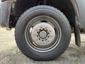 A close-up view of a Michelin tire mounted on a wheel with a silver rim showing multiple lug nuts on a 2015 Ford F-550