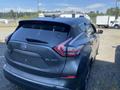 A 2017 Nissan Murano in grey featuring sleek lines and modern design elements with prominent rear lights and a curved roofline