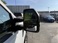 A 2021 Ford F-150 side mirror reflecting its surroundings with a clear view of the exterior and adjacent vehicles