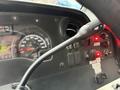 Close-up of a 2012 Ford Econoline dashboard featuring a speedometer ignition switch and various control lights