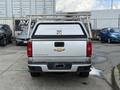 A 2018 Chevrolet Colorado with a silver exterior and a black bed cover features a rack on top and is parked in a lot