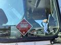 A red and white technical safety sticker for a propane system on a 2009 Workhorse W62 vehicle window with the number 1075 and a blue flame symbol