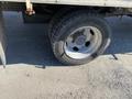 A flat tire on a 2014 Hino 195 truck visible on the side of the vehicle with a silver rim and textured tire treads