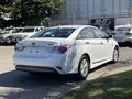 A white 2015 Hyundai Sonata with a hybrid badge parked with no license plate attached