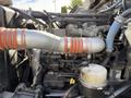 Close-up of the engine components of a 2008 Kenworth T370 showing pipes and connectors with a focus on a large aluminum intake pipe and associated machinery