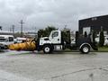 A 2016 Freightliner 108SD equipped with a large yellow snow plow attachment facing to the right