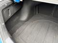 The trunk of a 2021 Kia Forte featuring a black carpeted floor with a smooth design and a side compartment