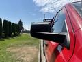 A red 2013 RAM 2500 with a focus on its side mirror and sleek body design