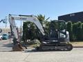 A 2010 Bobcat E80 compact excavator featuring a bucket attachment and a tracked undercarriage