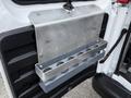 A metal storage rack mounted on the interior door of a 2016 GMC Savana designed to hold multiple cylindrical objects