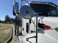A 2020 Peterbilt 330 truck with a polished side mirror and a logo visible on the door in a bright silver color