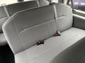 A row of gray fabric seats in a vehicle with seat belts attached