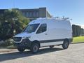 A 2024 Mercedes-Benz Sprinter 2500 in white with a black stripe showcasing a spacious cargo area and roof-mounted racks