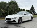 A 2016 Maserati Ghibli in white with a sleek design featuring a distinctive grille and sporty alloy wheels
