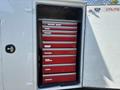 A 2011 Ford F-550 utility vehicle with an open storage compartment displaying multiple red tool drawers organized neatly in a stack