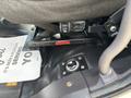 A view of the base of a driver's seat in a 2013 Freightliner 114SD showing metal support brackets and a circular fuel tank access port