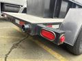 A 2005 Katolight SED60FPJ4 generator with an exhaust pipe on one side and a red marker light on the other side mounted on a flatbed trailer
