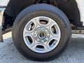 Close-up of a 2023 Ford F-350 SD wheel showing a silver alloy rim and a black tire with the word GENC on it