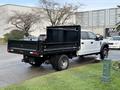 A 2017 Ford F-450 Super Duty truck with a flatbed in a black color parked at an angle showcasing its rear side and tires