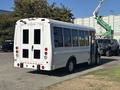 A white 2017 Ford Transit-350 shuttle bus with large windows and a rear door open, designed for passenger transport