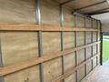 A 2024 Ford E-450 van interior featuring wooden beams mounted on the walls for cargo support