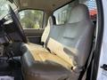 The interior of a 2008 Ford F-450 SD featuring a tan leather bench seat with seatbelts and a steering wheel