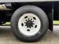 Close-up of a black tire mounted on a white wheel with six lug nuts visible on a 2007 GMC F7500 truck