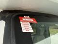 A 2017 Ford E450 displays a red certificate of approval sticker attached to the window indicating the months January to May and the year 2026