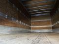 Interior view of a 2014 International TerraStar cargo truck showing a wooden floor and wooden walls with metal framing and a high ceiling