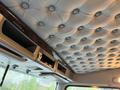The interior ceiling of a 2018 Kenworth T800 featuring stitched leather upholstery with a tufted design and overhead compartments for storage