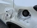 A close-up of the fuel cap area on a 2021 Toyota C-HR showing the open fuel door with the gas cap secured inside