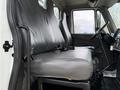 Interior view of a 2011 International 4300 showing a gray bench seat and the driver's side controls and dashboard